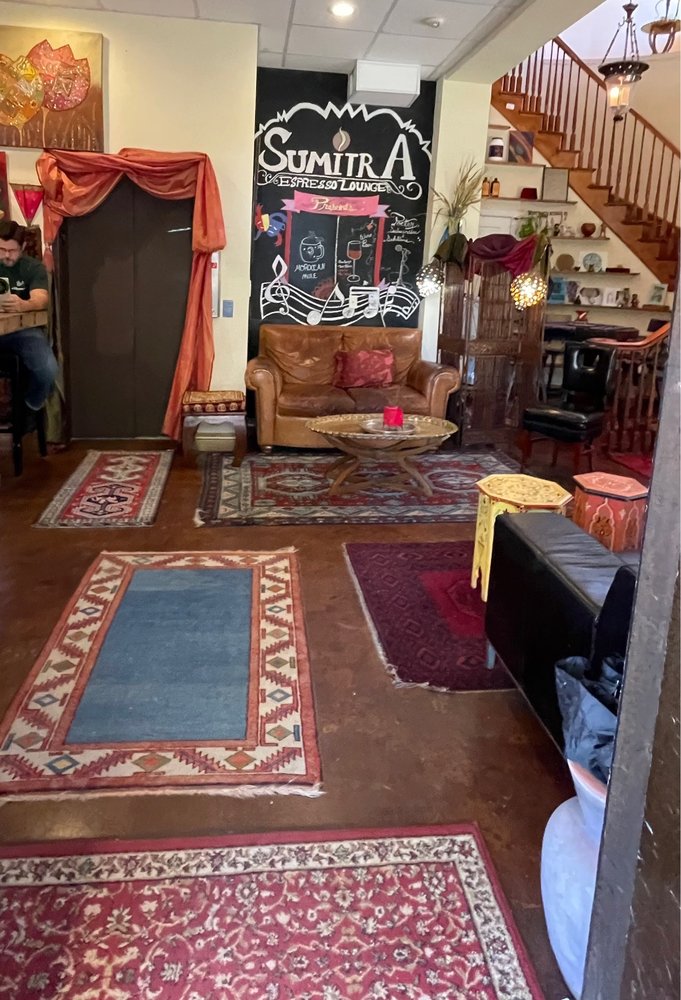 Rugs and lounge chairs below the chalk SumitrA mural