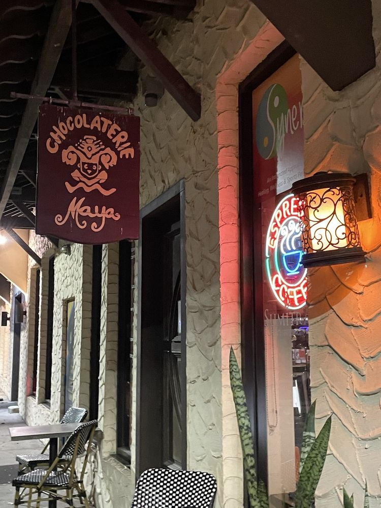 The Chocolaterie Maya sign and lantern on the stucco wall by the door