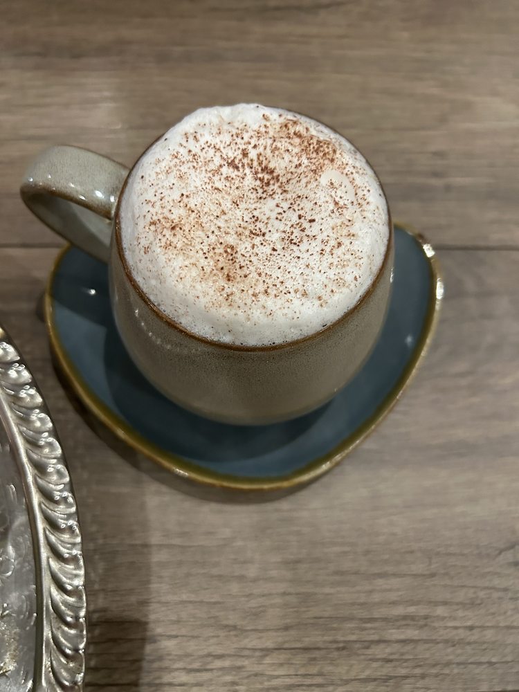 A cinnamon-dusted cappuccino in a grey stoneware cup