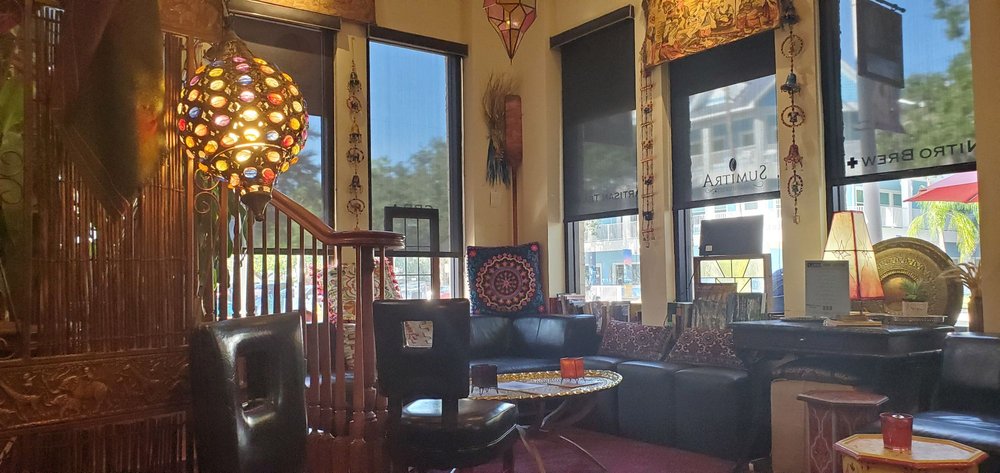 SumitrA's upstairs lounge: a lantern, the staircase rail and leather seats by sunny windows