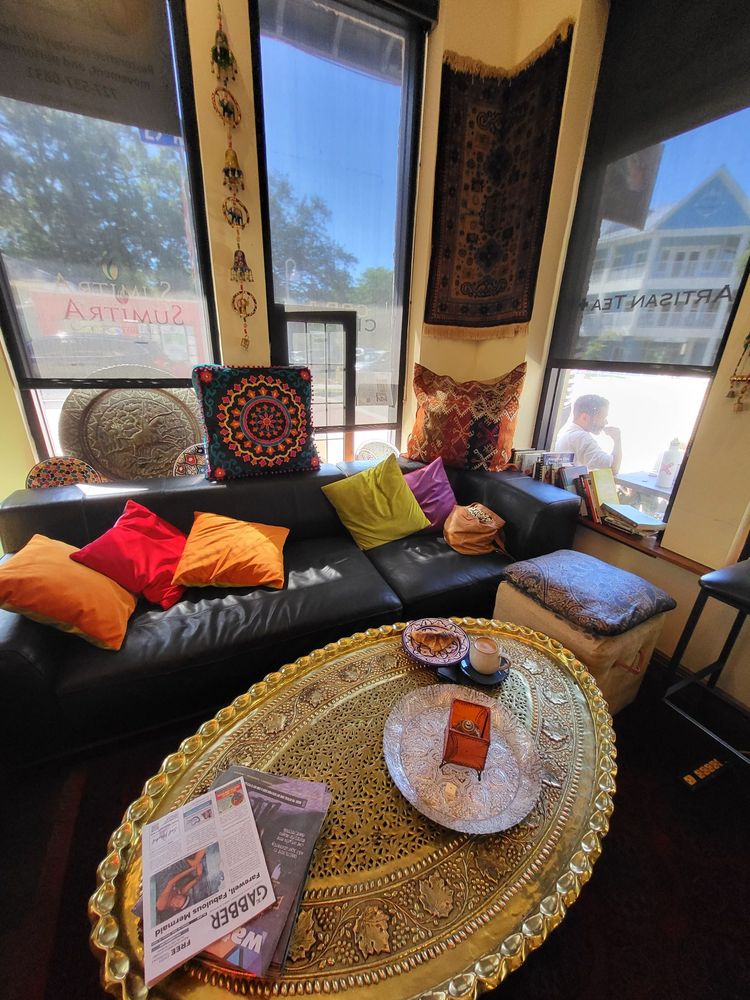 Leather couches heaped with bright cushions beside SumitrA's tall front windows