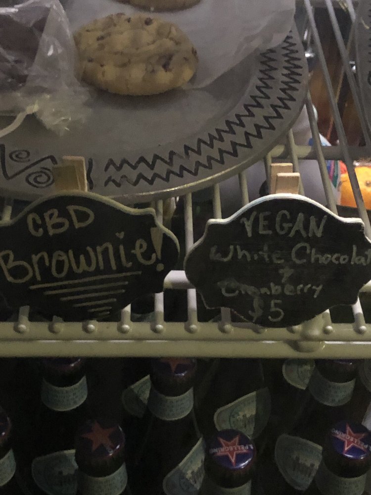 Chalk tags reading CBD Brownie and Vegan White Chocolate Cranberry in SumitrA's case