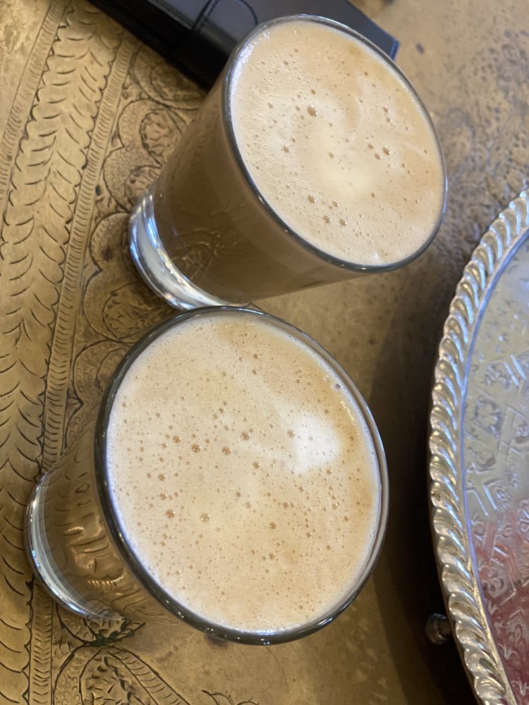 Overhead: two lattes beside an etched silver tray