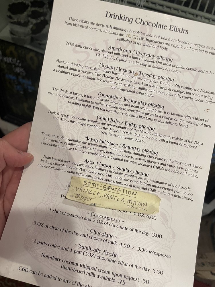 The printed Drinking Chocolate Elixirs menu held up in the lounge