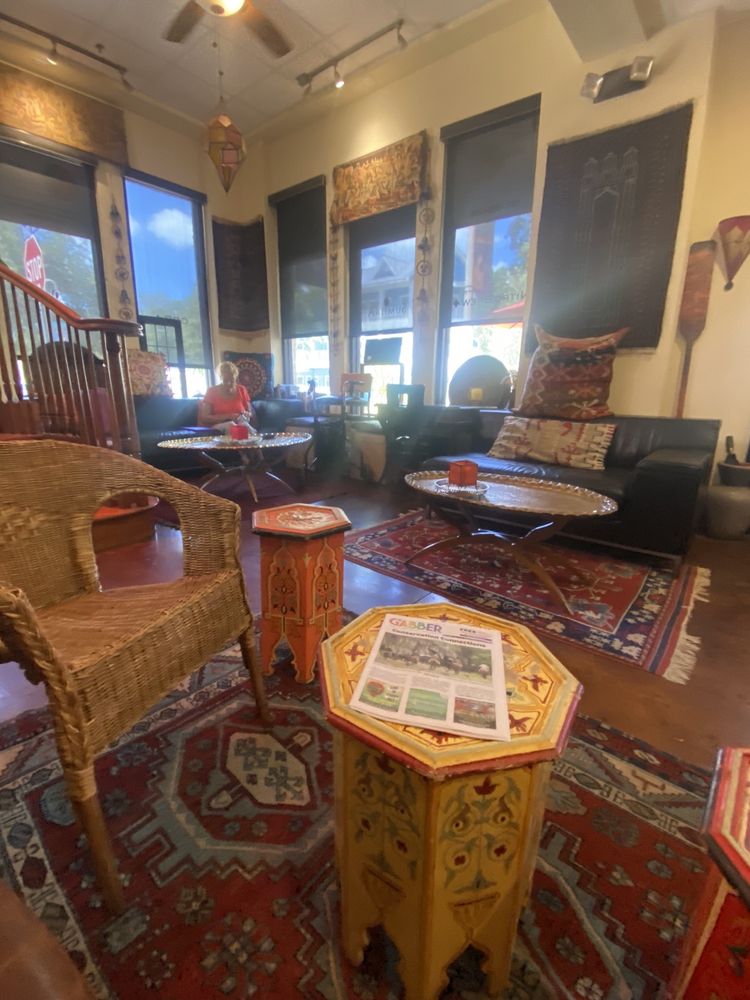 Wicker chairs and a painted octagon table on a red rug