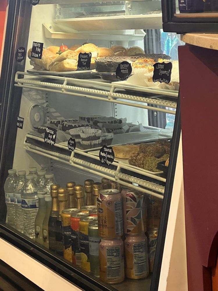 SumitrA's pastry case above shelves of bottled sodas and water