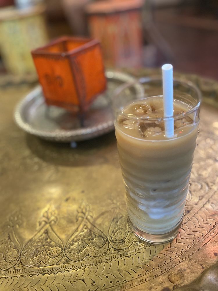 Iced latte on ornate brass tray